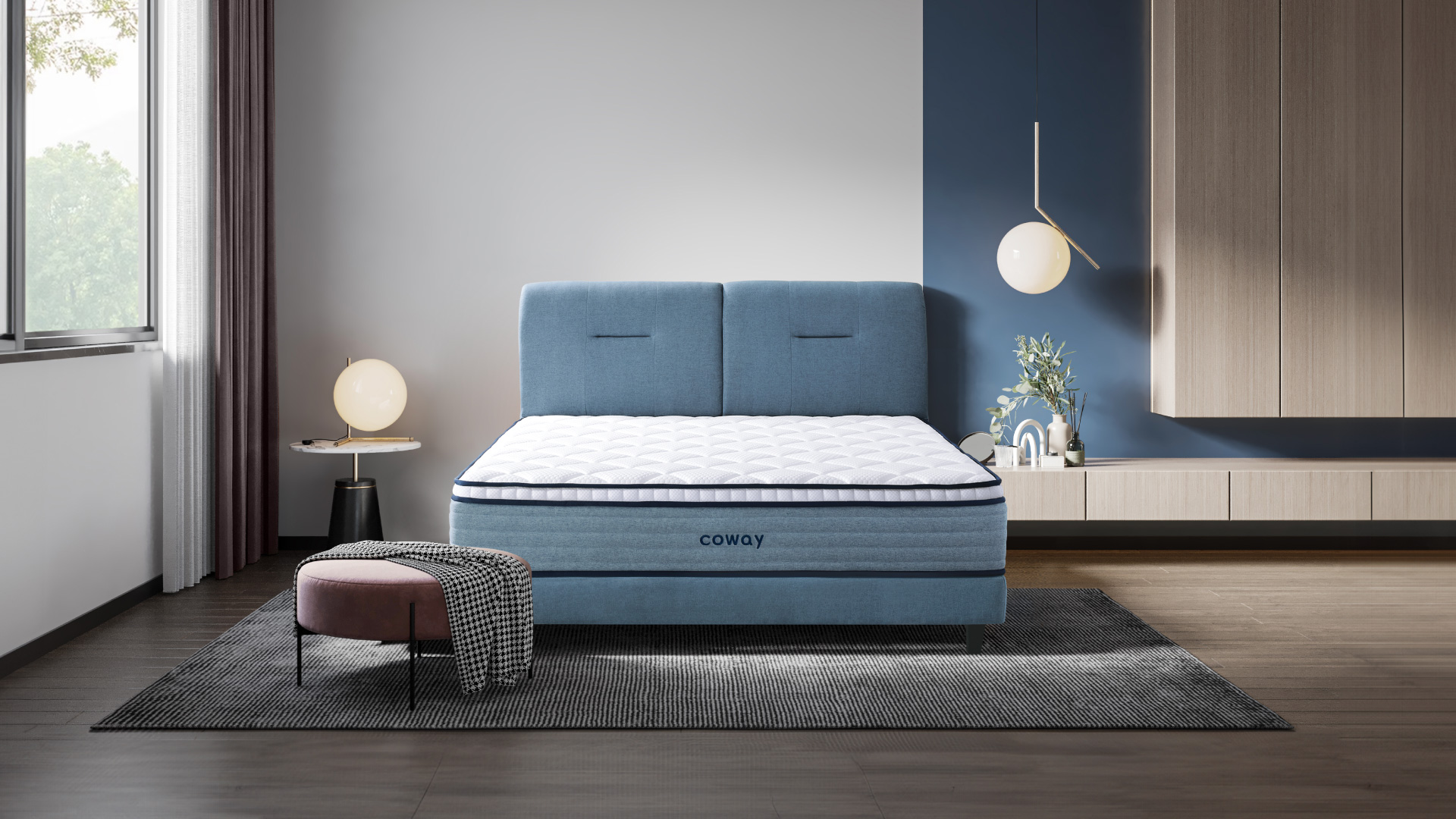 Coway Prime Lite Series Mattress At The Center Of The Room With A Rug Underneath And A Low Chair With A Rug Draped Across - Coway Prime Lite Series