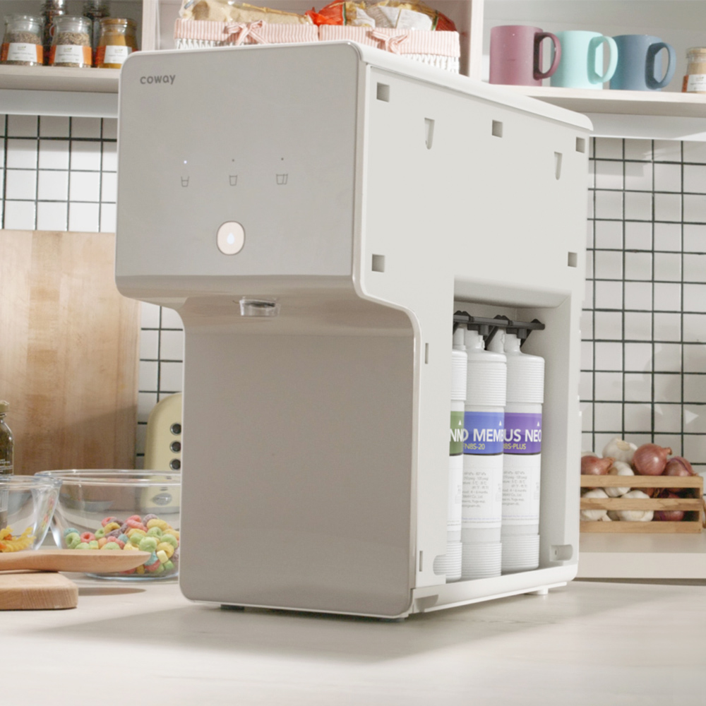 Diagonal View Of Table Top Water Purifier In The House Kitchen Together With The Water Filters - Coway Cinnamon